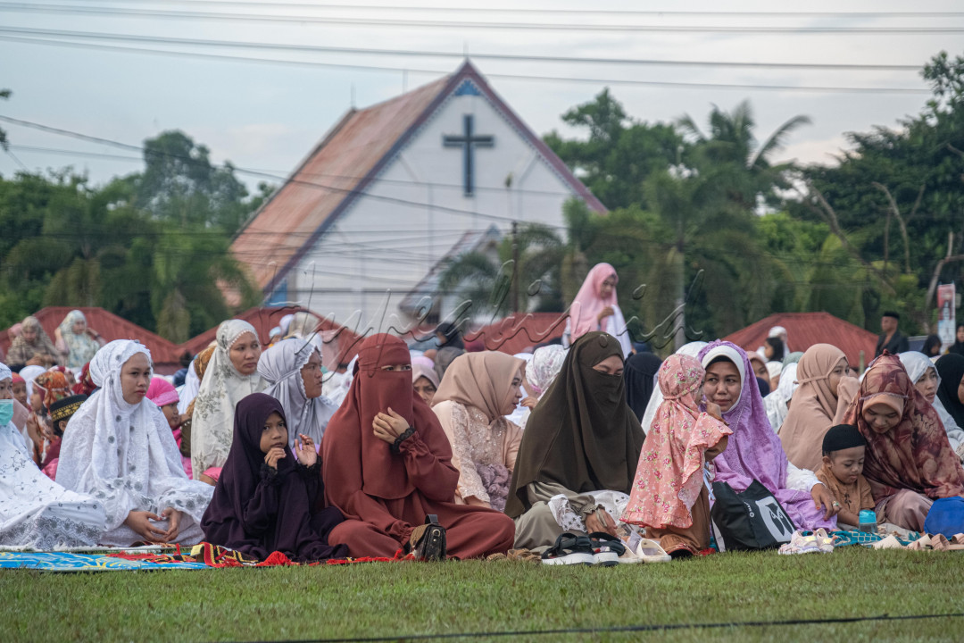 Barisan Jemaah wanita sedang melaksanakan Shalat Idul Fitri 1444 Hijriah berdampingan dengan gereja di Lapangan Sorumba, Ranomeeto, Konawe Selatan.&nbsp;<br />
&nbsp;