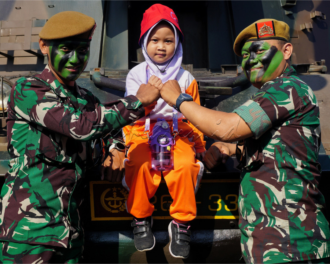 Potret dua anggota TNI di Armed Cimahi saat HUT ARMED yang ke-78, bersenang hati untuk Bersosialisasi melayani seorang anak Generasi Bangsa yang ingin berfoto bersama anggota TNI tersebut.&nbsp;