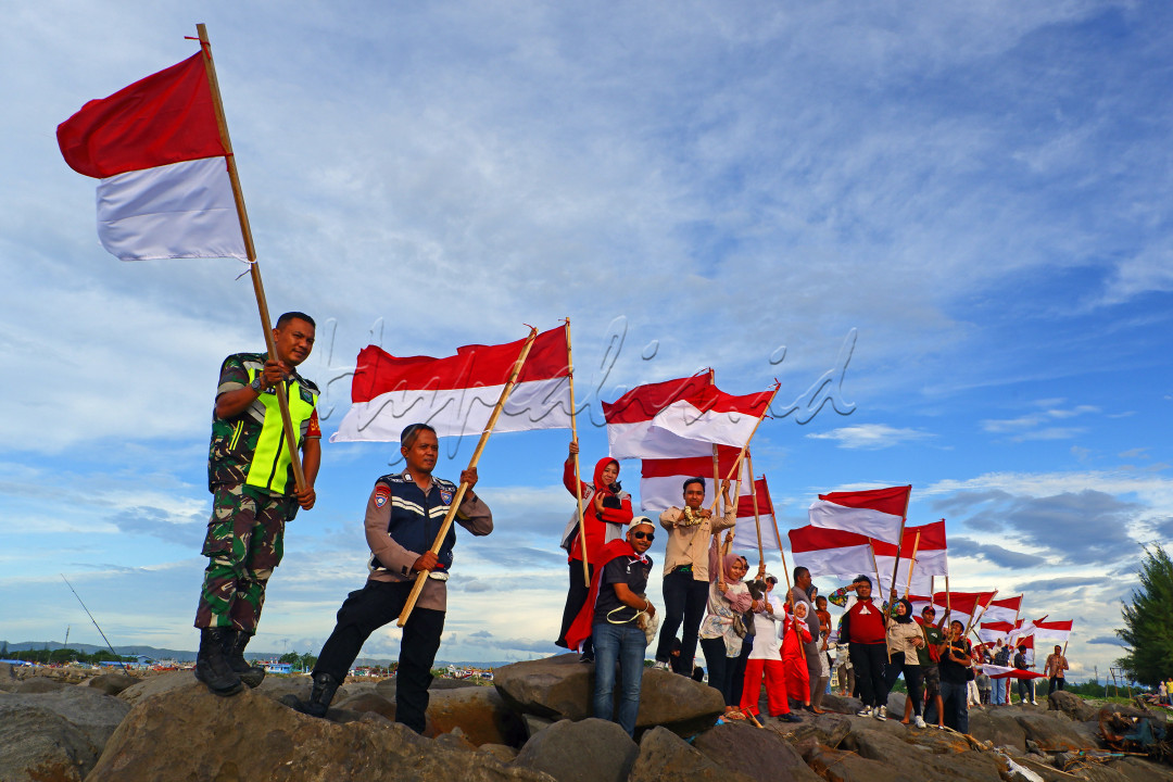 Sejumlah anggota dari berbagai komunitas di Banda Aceh saat melakukan parade merah putih dalam rangka memeriahkan HUT RI-78 di Pantai Gampong Jawa, pada Selasa, (15/08/2023). Hal ini merupakan sebuah solidaritas dan kolaborasi dalam bingkai kebhinnekaan Indonesia.