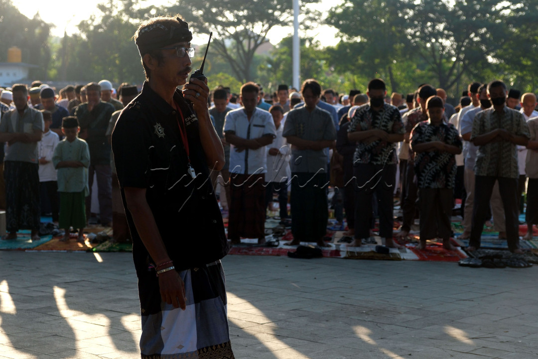 Pecalang atau satuan pengamanan desa adat Bali berjaga saat umat Islam melaksanakan salat Idulfitri 1444 H di Lapangan Lumintang, Denpasar, Bali. Sabtu (22/4/2023). Pengamanan Salat Idulfitri tersebut melibatkan sebanyak 15 orang Pecalang.