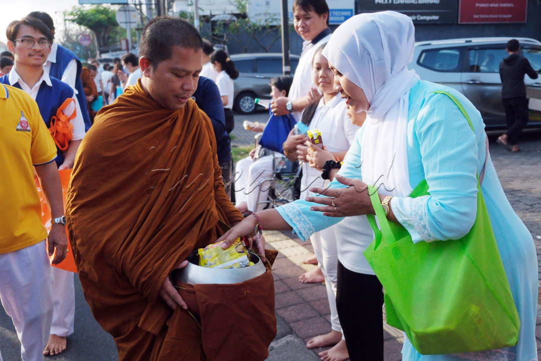Umat Islam memberikan makanan kepada biksu saat tradisi Pindapata di sepanjang jalan menuju Vihara Buddha Sakyamuni, Denpasar, Bali, Kamis (1/6/2023). Tradisi yang sempat vakum selama tiga tahun akibat pandemi COVID-19 tersebut kembali digelar dengan diikuti sekitar 700 umat dalam rangkaian peringatan Hari Trisuci Waisak 2567 BE/2023 yang jatuh pada Minggu (4/6/2023).&nbsp;