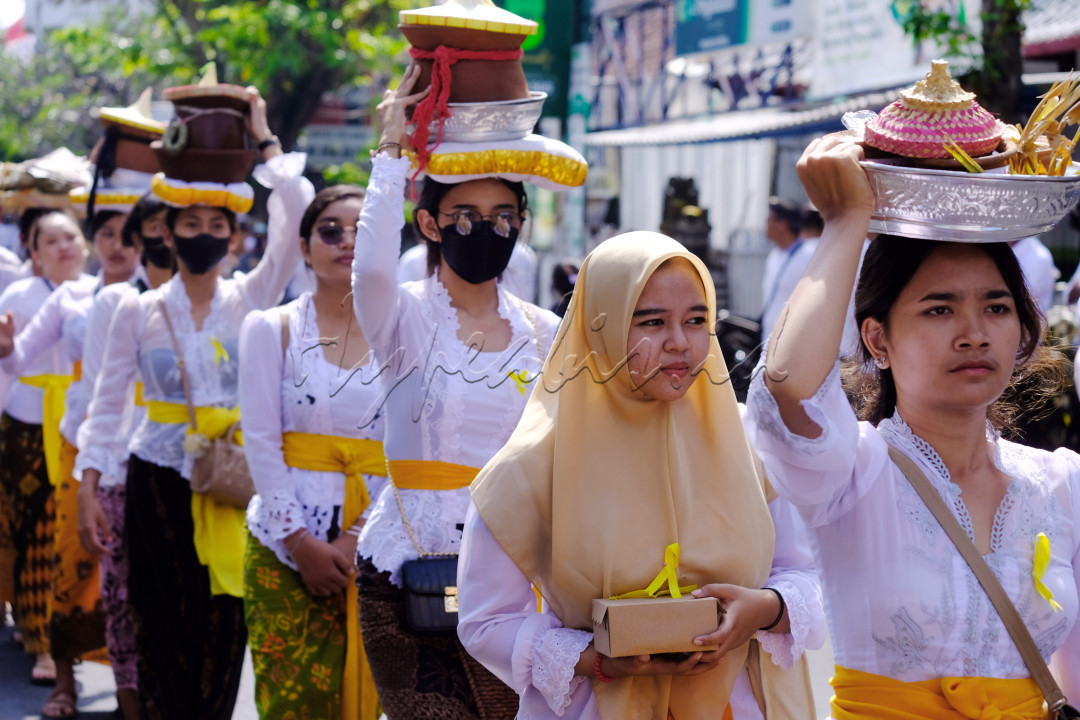 Seorang umat Islam ikut berjalan beriringan dengan sejumlah umat Hindu yang membawa sesajen saat Upacara Pelebon Raja Denpasar IX Ida Tjokorda Ngurah Jambe Pemecutan di Denpasar, Bali, Rabu (21/6/2023).
