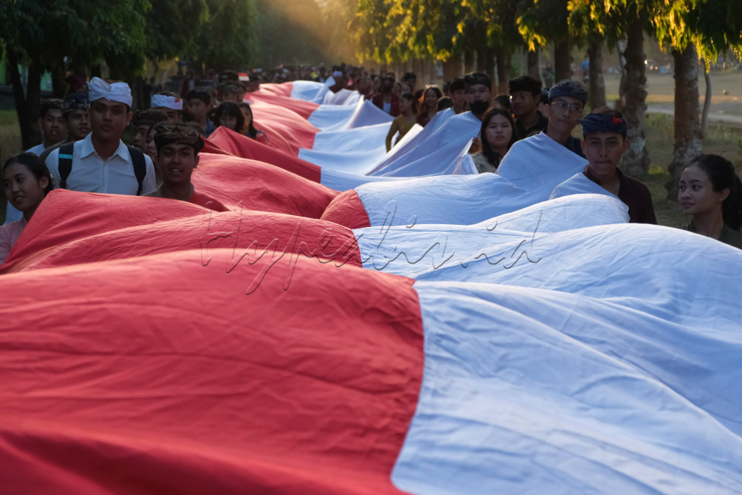 Etnis Nusantara berkeliling membentangkan bendera merah putih saat puncak Gema Perdamaian ke-21 di area Monumen Bajra Sandhi, Denpasar, Bali, Sabtu (14/10/2023). Kegiatan yang mengusung tema Refleksi Budi Luhur Menuju Perdamaian tersebut diikuti sekitar 3.000 peserta dari berbagai kelompok masyarakat untuk mengingatkan kembali pentingnya perdamaian.
