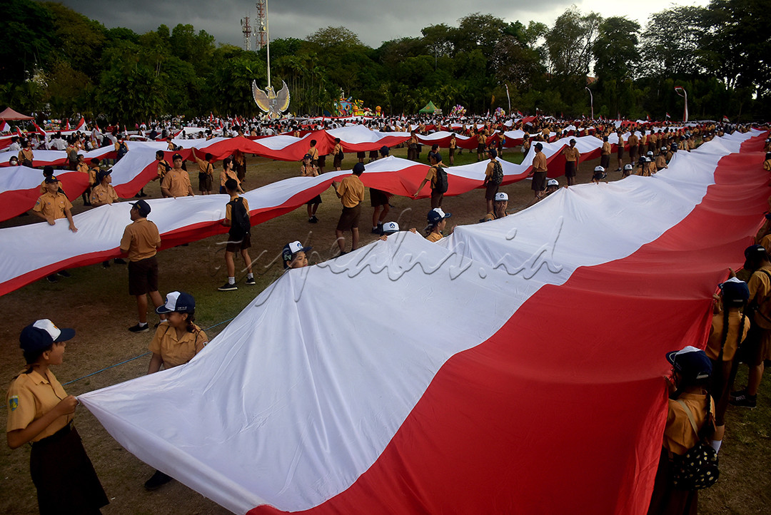 Pelajar membentangkan bendera merah putih saat mengikuti Kirab Merah Putih di Denpasar, Bali, Minggu (12/11). Kirab bendera merah putih sepanjang 1.001 meter yang diikuti ribuan pelajar, personel TNI Polri dan berbagai kelompok masyarakat itu diselenggarakan untuk memperkuat rasa kebangsaan dan nasionalisme pada momentum Hari Pahlawan dan Sumpah Pemuda 2023.&nbsp;