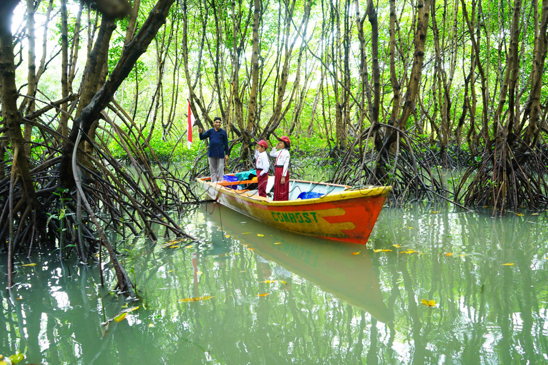 Potret seorang Ayah menegakkan benderanya dengan rasa semangat dan khidmat untuk melakukan kegiatan upacara Kemerdekaan Indonesia bersama kedua anaknya di Hutan Mangrove Sidorukun, Kabupaten Gresik, Jawa Timur