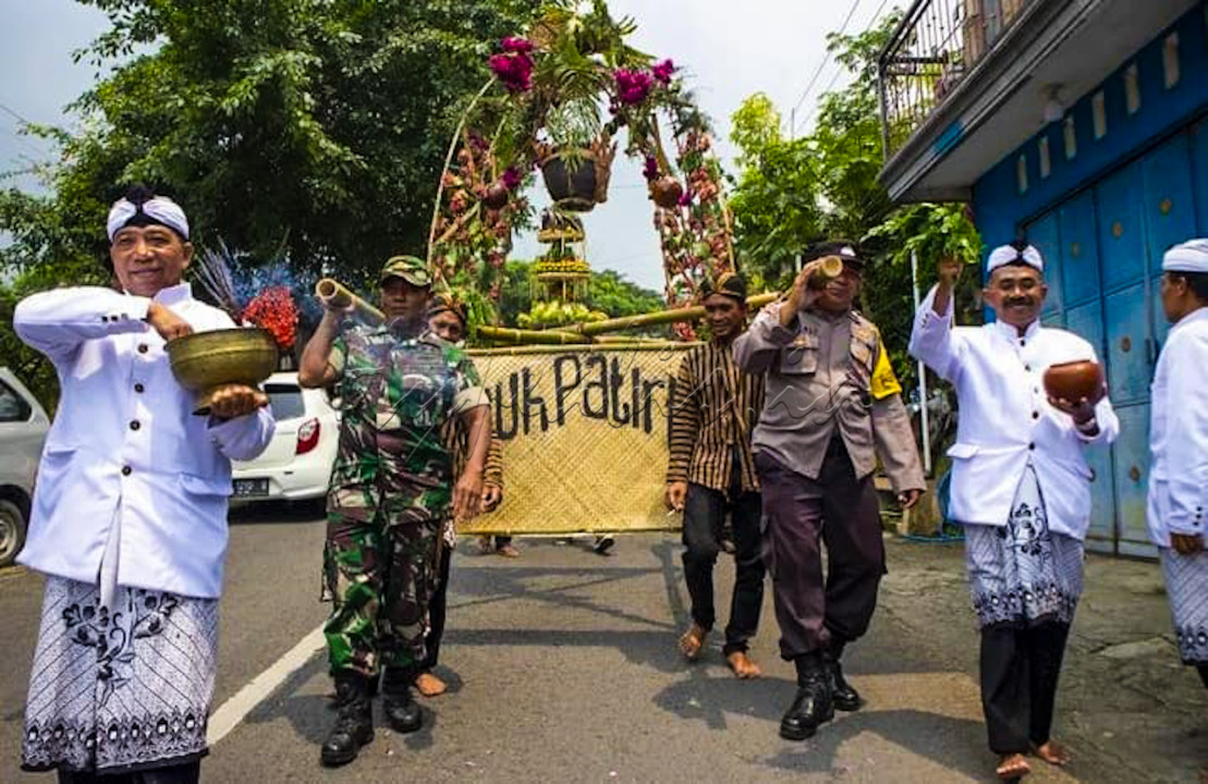 Anggota TNI dan Polisi ikut serta menggotong sesaji dalam acara bersih desa masyarakat budaya Kembangbelor, Pacet, Mojokerto. Aksi TNI, Polisi dan masyarakat ini wujud kebersamaan damai dalam perbedaan.