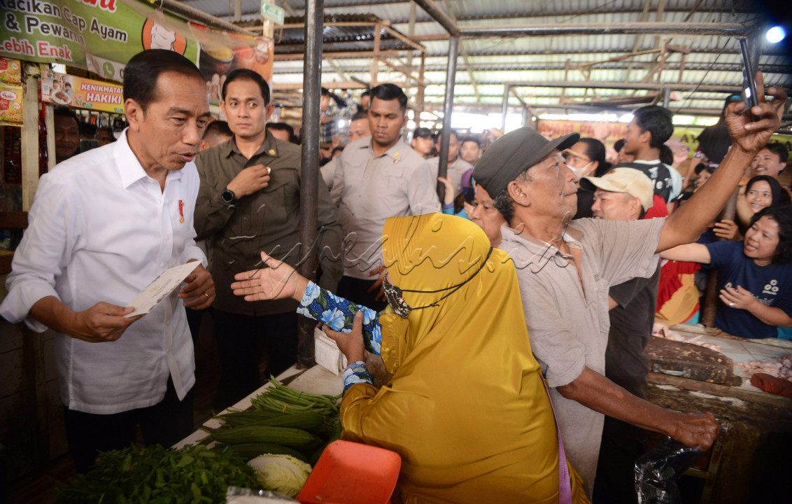 Seorang pedagang sayur di Pasar Sekip Ujung Palembang (26/10), berusaha sekuat tenaga mengabadikan dirinya bersama istri yang sedang didatangi Presiden Jokowi. Kesempatan langka tersebut dimanfaatkannya dengan berselfi menggunakan handpone. Kedatangan Jokowi ke pasar tersebut menaikkan moril dan semangat pedagang.