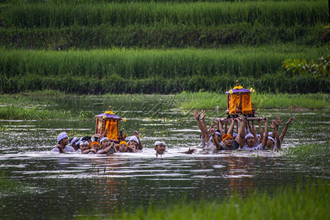Sebuh prosesi ritual agama Hindu yang ada di kabupaten Karangasem Bali yang disebut tradis Meyab dimana tradisi unik ini adalah prosesi penyucian sarana upacara dengan melewati danau.
