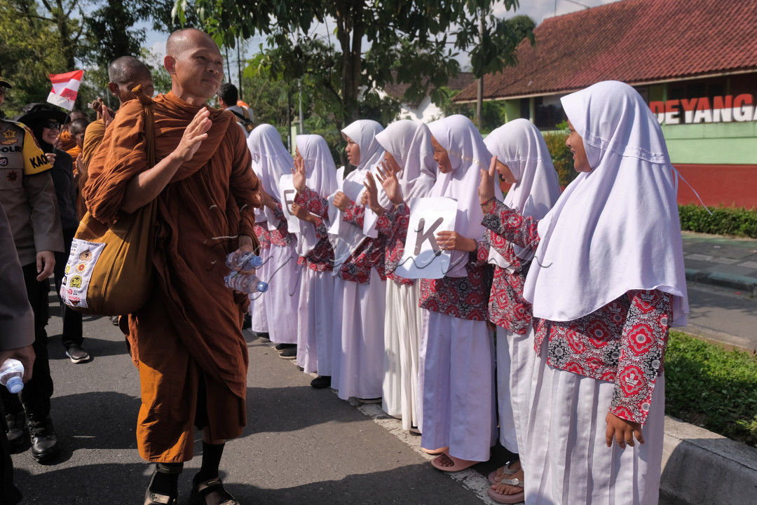 Sejumlah pelajar menyambut kedatangan Biksu Thudong pada rute terakhir Magelang-Borobudur di Deyangan, Mertoyudan, Magelang, Jawa Tengah, Rabu (31/5/2023). Warga masyarakat di sepanjang rute yang dilalui biksu Thudong menyambut dengan penuh keramahan.