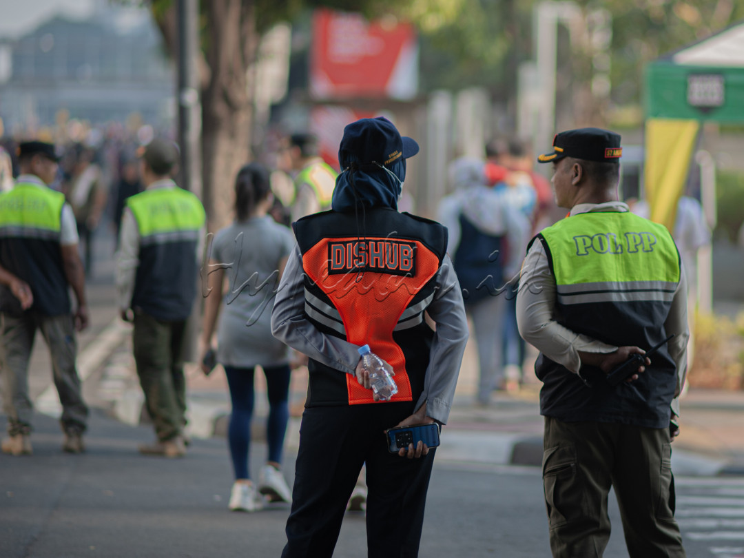 dua orang aparat menjaga keamanan dan kenyamanan masyarakat ketika diadakan car free day disalah satu jalan Utama Jakarta