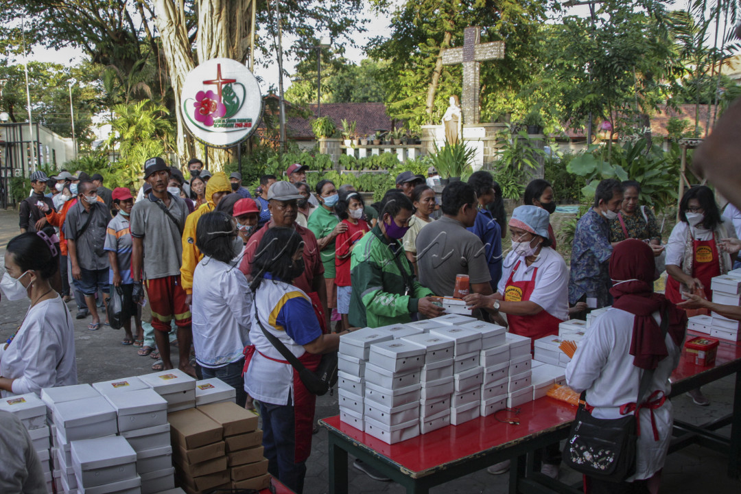 Warga mengantre untuk mendapatkan makanan berbuka puasa dalam Aksi Piring Kasih di halaman Gereja St Theresia Bongsari, Kota Semarang, Jawa Tengah, Kamis 23 Maret 2023. Program aksi piring kasih dengan membagikan lebih dari 250 paket makanan kepada warga lintas agama yang biasanya dilaksanakan setiap hari Kamis pada jam makan siang diubah menjelang waktu buka puasa bertepatan dengan bulan Ramadhan sebagai wujud kepedulian serta toleransi terhadap seluruh umat beragama untuk saling berbagi.