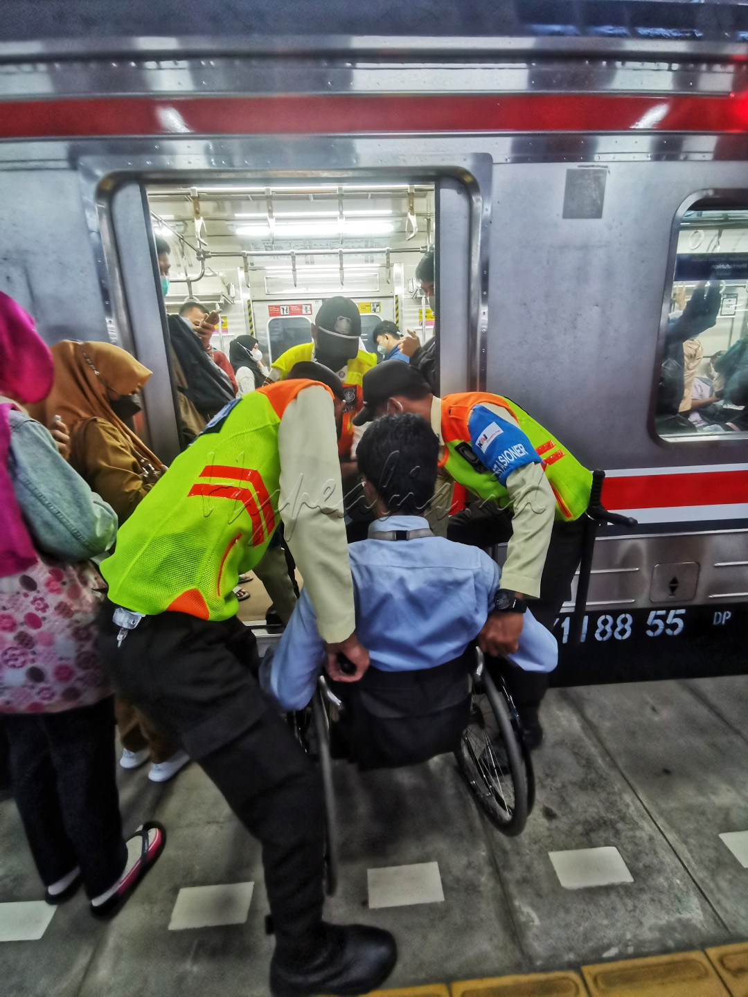 Pengguna kursi roda dibantu oleh petugas untuk memasuki gerbong Commuter Line di Stasiun Bekasi.&nbsp;&nbsp;