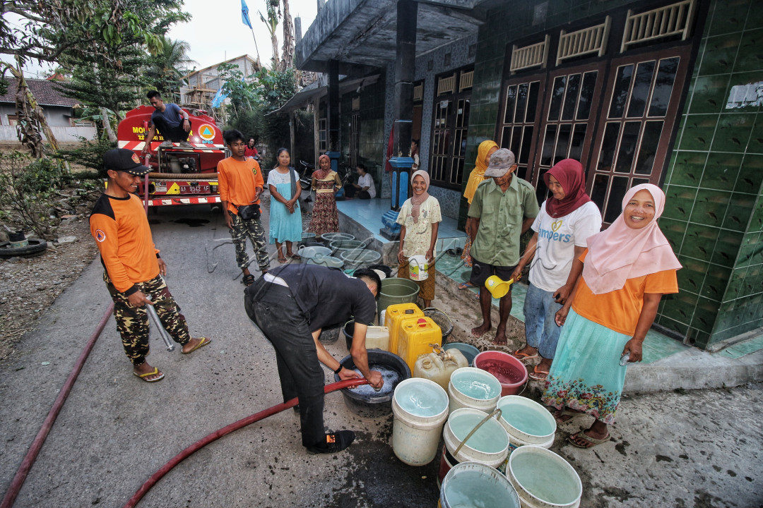 Relawan membagikan bantuan air bersih kepada masyarakat desa Kalidadap Wadaslintang Wonosobo Jateng, yang mengalami kekurangan air bersih ketika musim kemarau panjang.