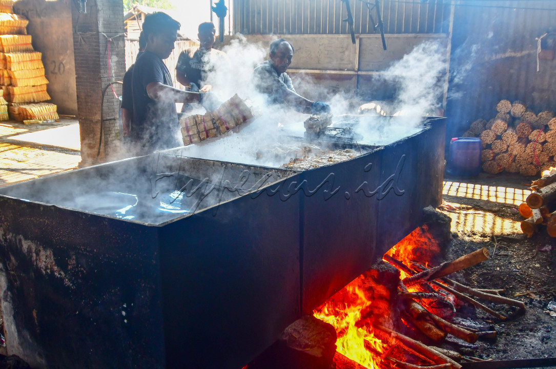 Pekerja sedang mengangkat keranjang bambu berisi ikan pindang di salah satu rumah produksi ikan pindang di Situbondo Jawa Timur, Ahad (17/9/2023).