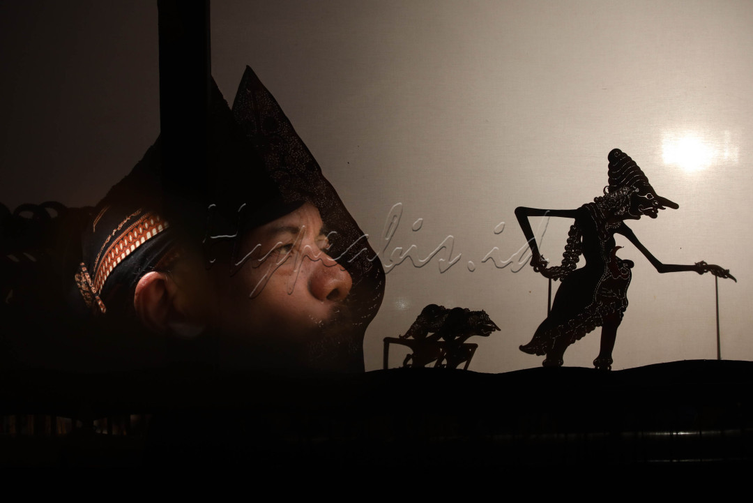 Dalang Ki Sri Susilo Tengkleng memainkan wayang kulit Wahyu Kamulyan di kawasan Taman Mini Indonesia Indah (TMII) saat malam pergantian tahun.