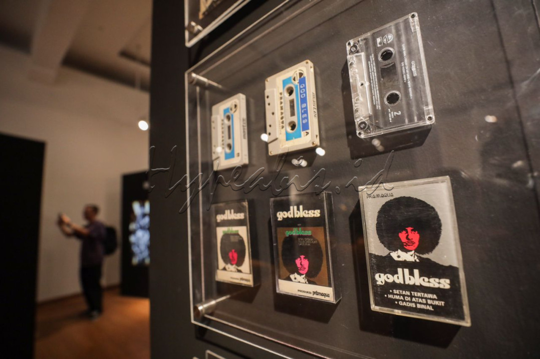 Pengunjung melihat koleksi karya pada pameran Retrospektif God Bless 50th di Galeri Nasional, Jakarta. Pameran yang berlangsung hingga 1 Maret 2024 ini memajang properti bersejarah milik God Bless seperti kostum panggung, alat musik yang digunakan untuk konser, rekaman piringan hitam hingga pita kaset.
