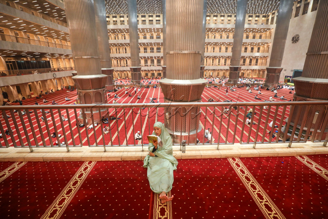 Seorang warga membaca Al Quran saat beriktikaf di Masjid Istiqlal, Jakarta.&nbsp;Beberapa lainnya terlihat khusyuk berzikir dan menjalankan salat malam, sementara yang lainnya ada yang beristirahat memejamkan mata sejenak. Itulah gambaran suasana Masjid Istiqlal Jakarta, lewat tengah malam.