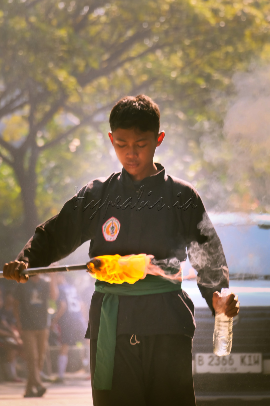 Foto ini menggambar kan seorang pesilat yang sedang bersiap siap untuk melakukan pertunjukan menyemburkan api dengan mata yang tertutup menciptakan seberapa fokus nya dan berani nya dari pesilat tersebut