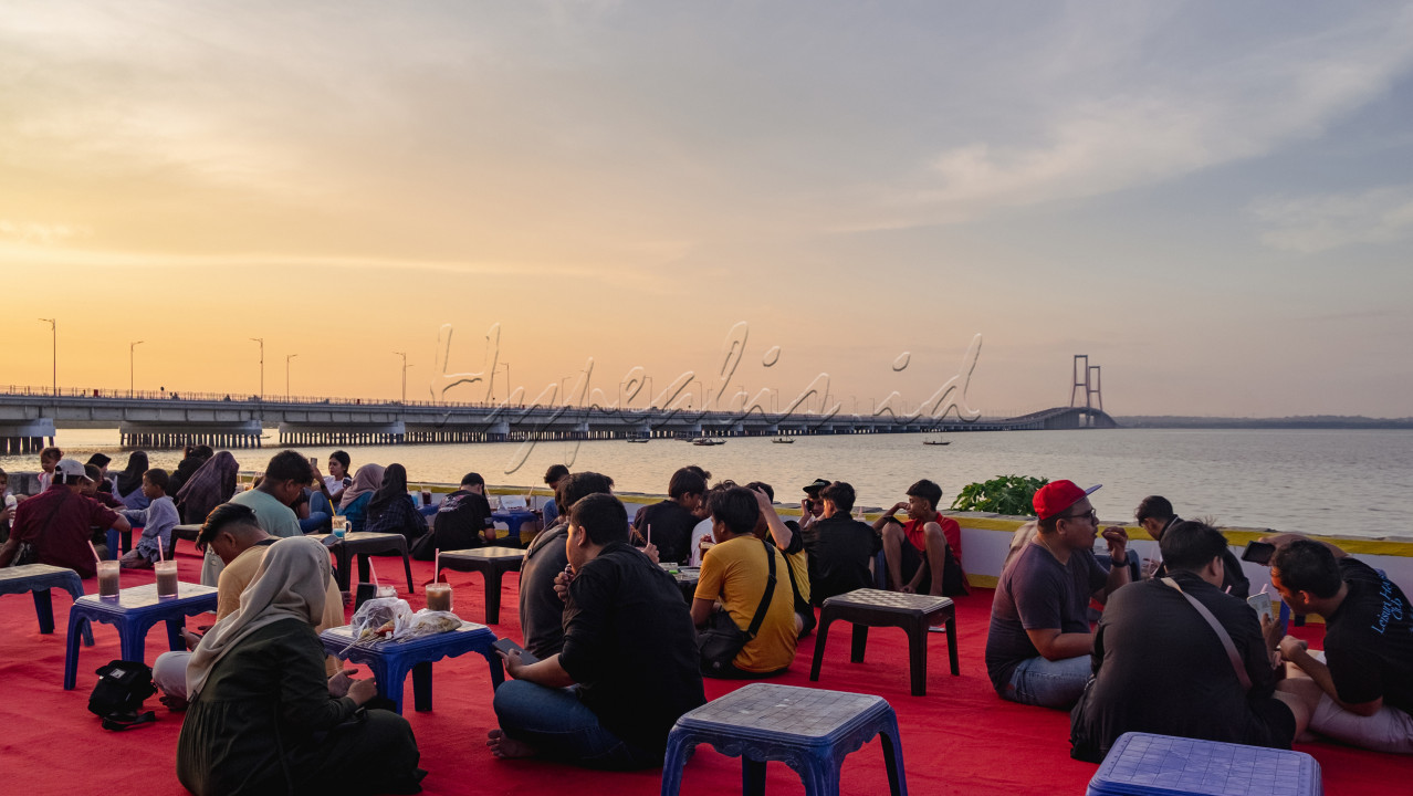 Masyarakat pesisir pantai kenjeran menikmati makanan dan minuman sambil melihat indahnya sunset dan megahnya Jembatan Suramadu&nbsp;