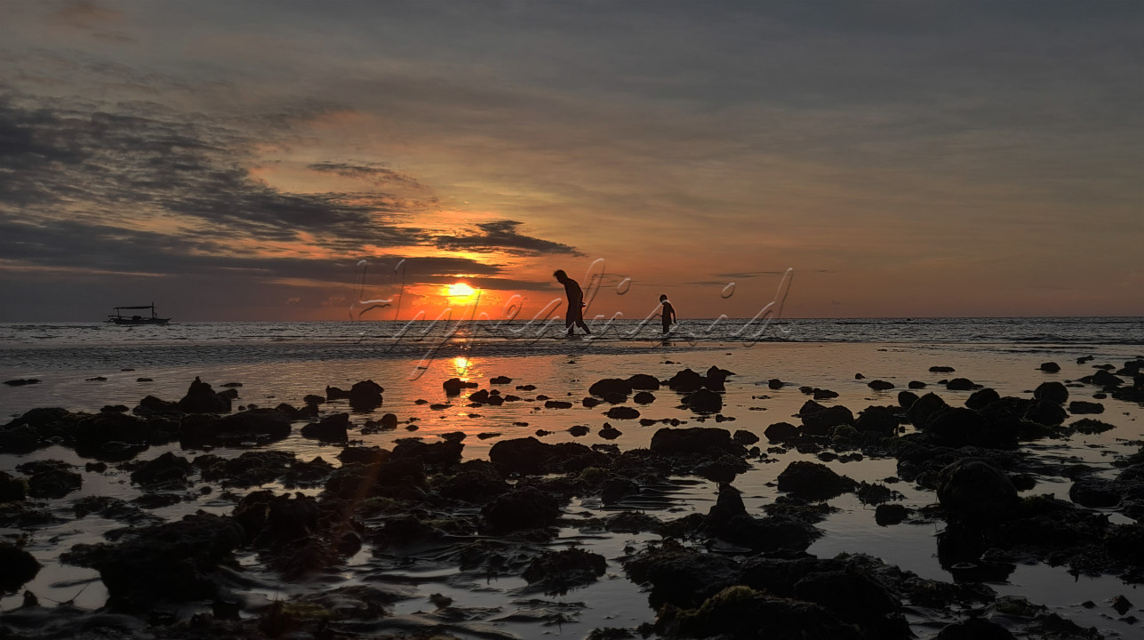Seorang anak sedang mengikuti ayahnya&nbsp; dipinggir Pantai Lovina, Bali.