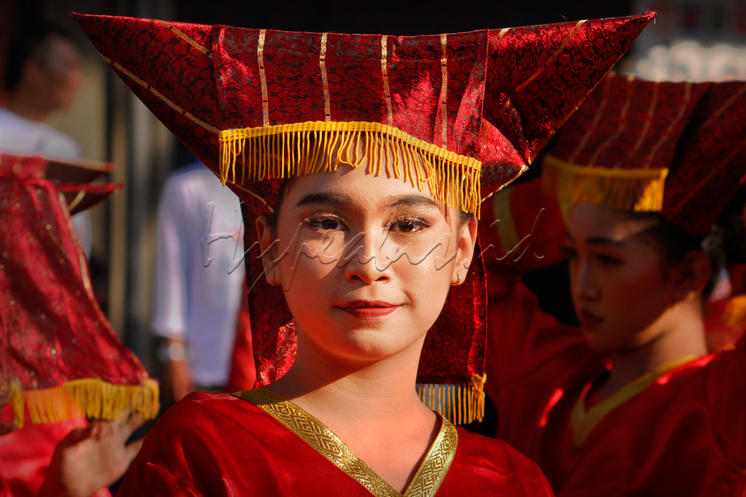 Paras cantik penari tradisional dengan senyum ramah mengenakan pakaian adat tari dari Sumatra berdiri menunggu bersama teman yang lain di jalan raya disaat menunggu pagelaran Hari Tari Nasional di Cimahi Jawa Barat.