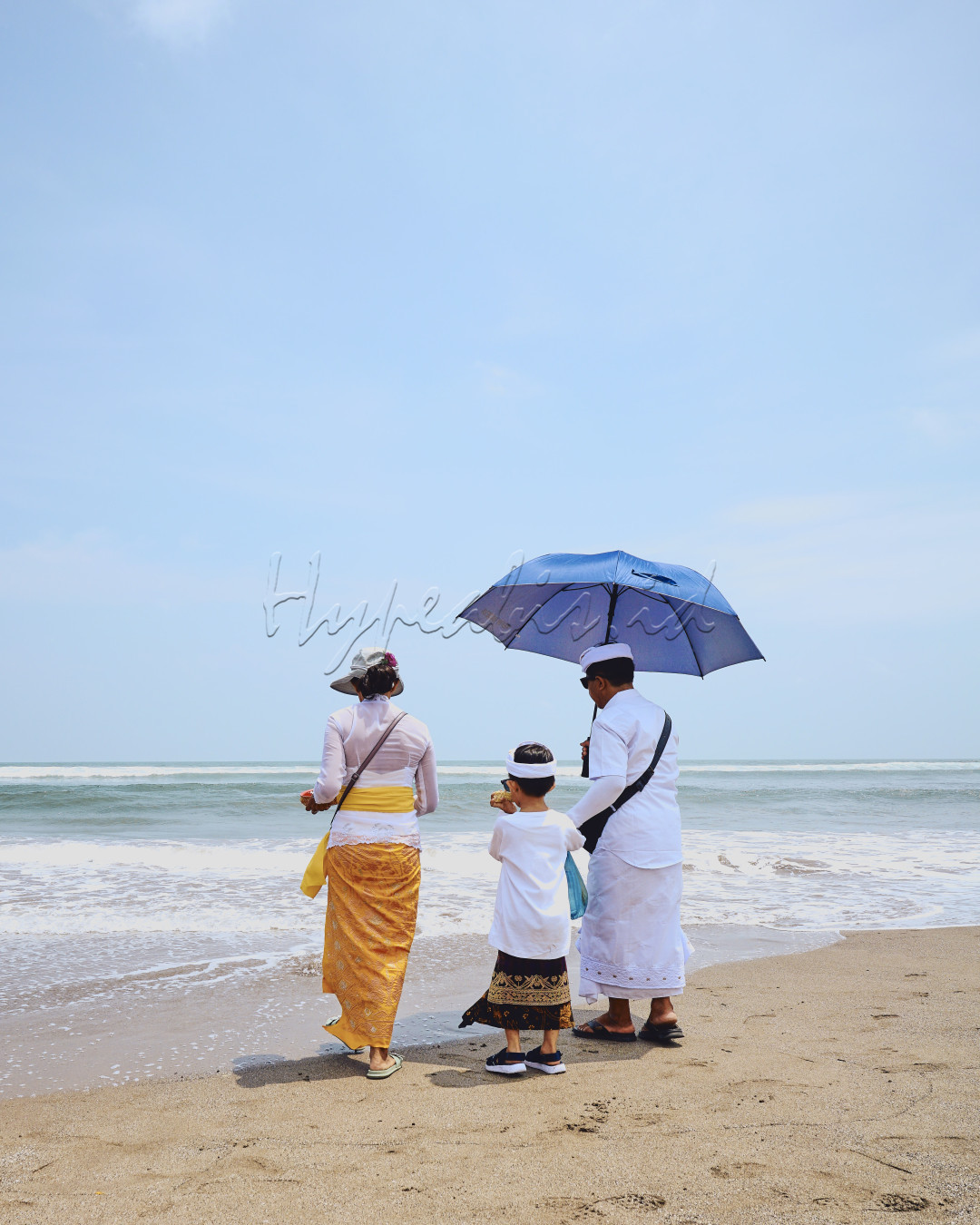 Terlihat keluarga terdiri dari Ayah, Ibu dan seorang anak nya. Mereka adalah penduduk lokal di Bali. Yang sedang melakukan suatu ritual keagamaan di pantai.