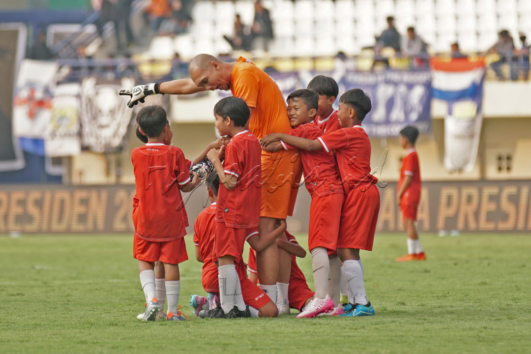 Anak-anak SSB memeluk mantan kiper Timnas Sepakbola Indonesia, Markus Horison saat laga eksebisi Pembukaan Piala Presiden 2024 di Stadion Si Jalak Harupat, Kabupaten Bandung, Jabar, 19 Juli 2024. Wajah bahagia para anak SSB terlihat saat mereka bertemu idola mereka di dunia sepakbola.