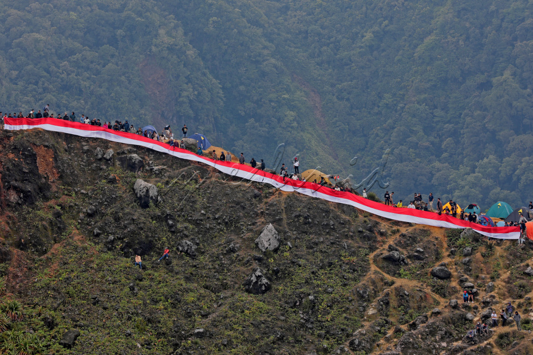 Puluhan Pemuda Pecinta Alam memegang bendera merah putih sepanjang 50 meter saat upacara perayaan HUT Ke-79 RI di Puncak Gunung Sibayak, Kabupaten Karo, Sumut, 17 Agustus 2024. Lebih dari 2000 orang merayakan Hari Kemerdekaan di tempat ini.