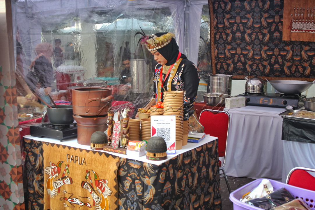 Perempuan dengan menggunakan pakaian tradisional Papua sedang membuat makanan khas Papua yaitu Papeda.
<div>Papeda memiliki tekstur yang kenyal dan nilai gizi yang tinggi.</div>