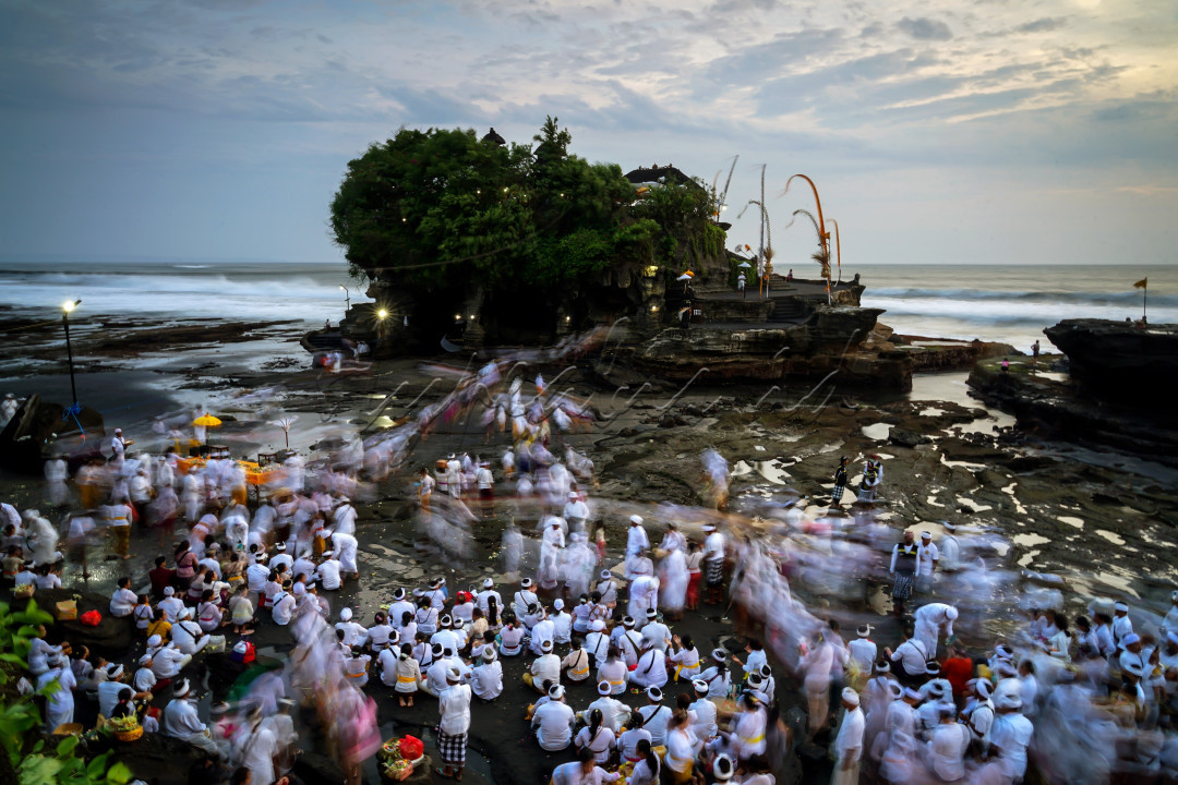 Acara persembahyangan di Pura Tanah Lot menjelang matahari terbenam.