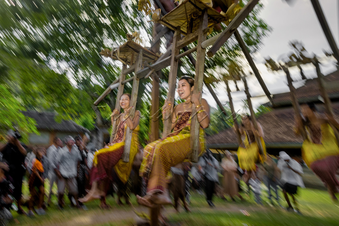 Ayunan jantra itu menjulang tinggi, kokoh, dan dihiasi dengan sentuhan-sentuhan artistik yang menggambarkan keindahan dan kekuatan alam. Dalam kain adat yang lembut dan berwarna-warni, para remaja putri berdiri di dekat ayunan dengan wajah penuh harap dan kekhusyukan. Mereka adalah penjaga tradisi, pewaris budaya, yang siap menjalani pengalaman yang akan membentuk dan menguatkan jiwa mereka.&nbsp;Para remaja putri berputar tertawa riang di ayunan, memperlihatkan keahlian dan keberanian yang melekat pada jiwa mereka. Mereka tersenyum serta tertawa riang, tetapi di balik itu terdapat rasa hormat yang mendalam terhadap tradisi nenek moyang mereka.&nbsp;Secara filosofis, permainan&nbsp;ayunan jantra&nbsp;ini memiliki makna sebagai perputaran kehidupan di dunia ini, dikaitkan dengan roda perputaran nasib, karma, perjalanan hidup mengabdi atau menjalankan kewajiban (swadharma) ketika masuk menjadi karma (warga).<br />
&nbsp;