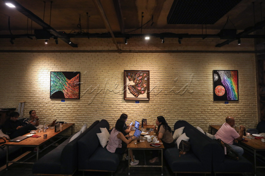Puluhan bingkai berisi karya seni terpasang di dinding sebuah restoran. Para pengunjung menyantap hidangan sambil berdialog santai dengan orang di depan atau di sebelahnya, sesekali memandangi dan menikmati karya-karya tersebut.&nbsp;
