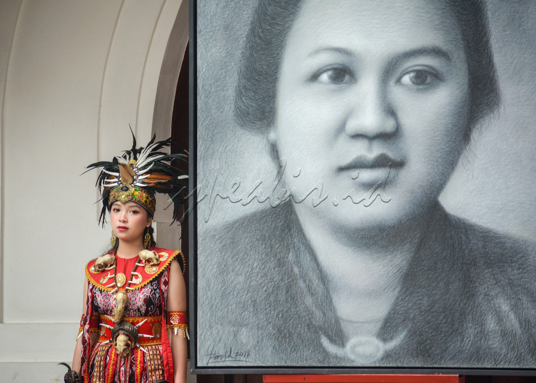 Potret seorang Gadis Dayak disamping Lukisan Wajah Raden Dewi Sartika saat acara 'Kendoeri Rakyat: Perempuan dalam bingkai Kemerdekaan' 17 Agustus 2024, yang diadakan oleh Gedung Indonesia menggugat, kota Bandung dalam memperingati Hari Kemerdekaan Indonesia ke-79 Tahun.<br />
Jika ada yang belum mengenal Raden Dewi Sartika, ia adalah seorang advokat dan tokoh perintis pendidikan untuk kaum wanita. Ia juga merupakan salah satu tokoh perempuan Indonesia paling terkenal. Ia diakui sebagai Pahlawan Nasional oleh Pemerintah Indonesia pada tahun 1966.