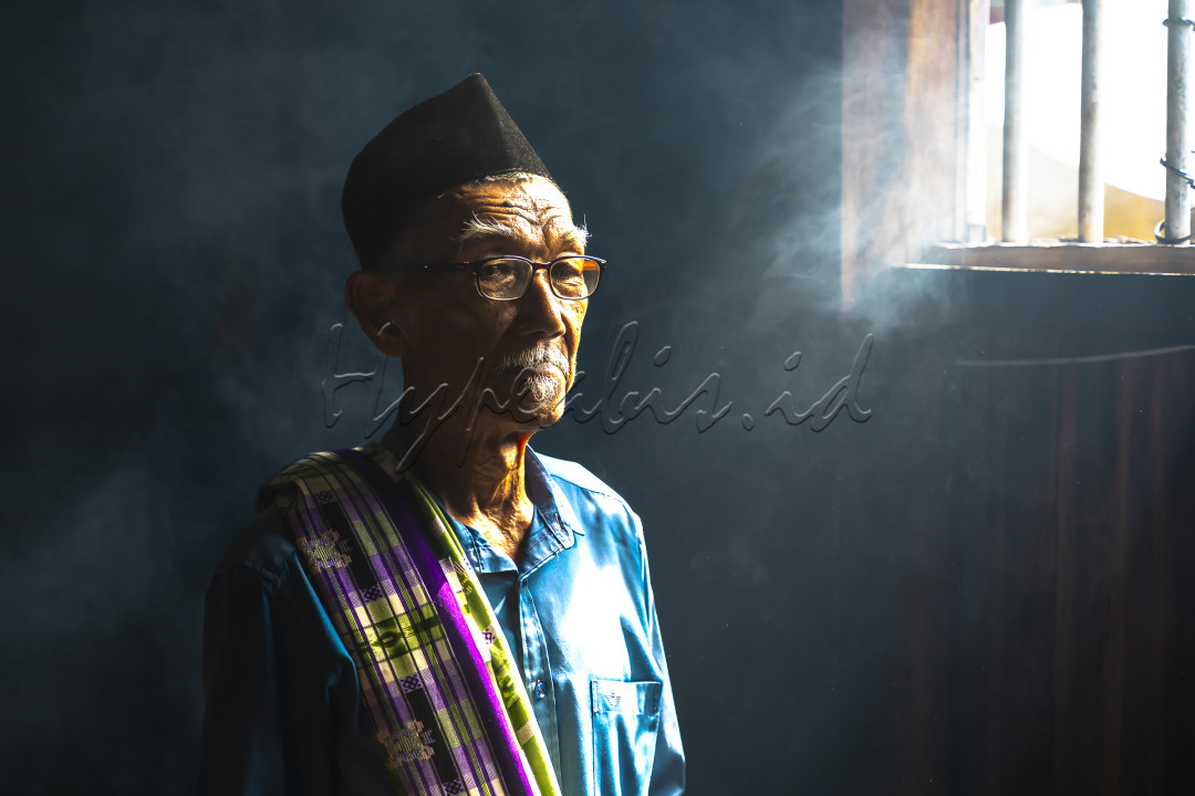 Foto potrait orang tua di sebuah kedai kopi dengan cahaya matahari yang masuk dari sela sela jendela