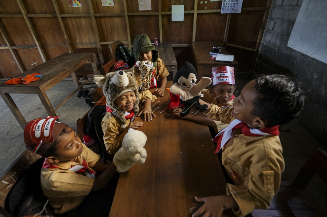 Di sebuah sekolah dasar yang ceria, suasana penuh kegembiraan mengisi halaman-halaman cerita hari ini. Para murid kelas dua berkumpul di sudut kelas, di mana mereka sedang terlibat dalam permainan yang memikat dengan boneka karakter favorit mereka. Dalam permainan ini,mereka tidak hanya berlatih keterampilan bercerita dan berimajinasi, tetapi juga belajar tentang kerja sama dan empati. Mereka saling mendengarkan ide satu sama lain dan bekerja bersama untuk menyelesaikan cerita yang mereka bangun.