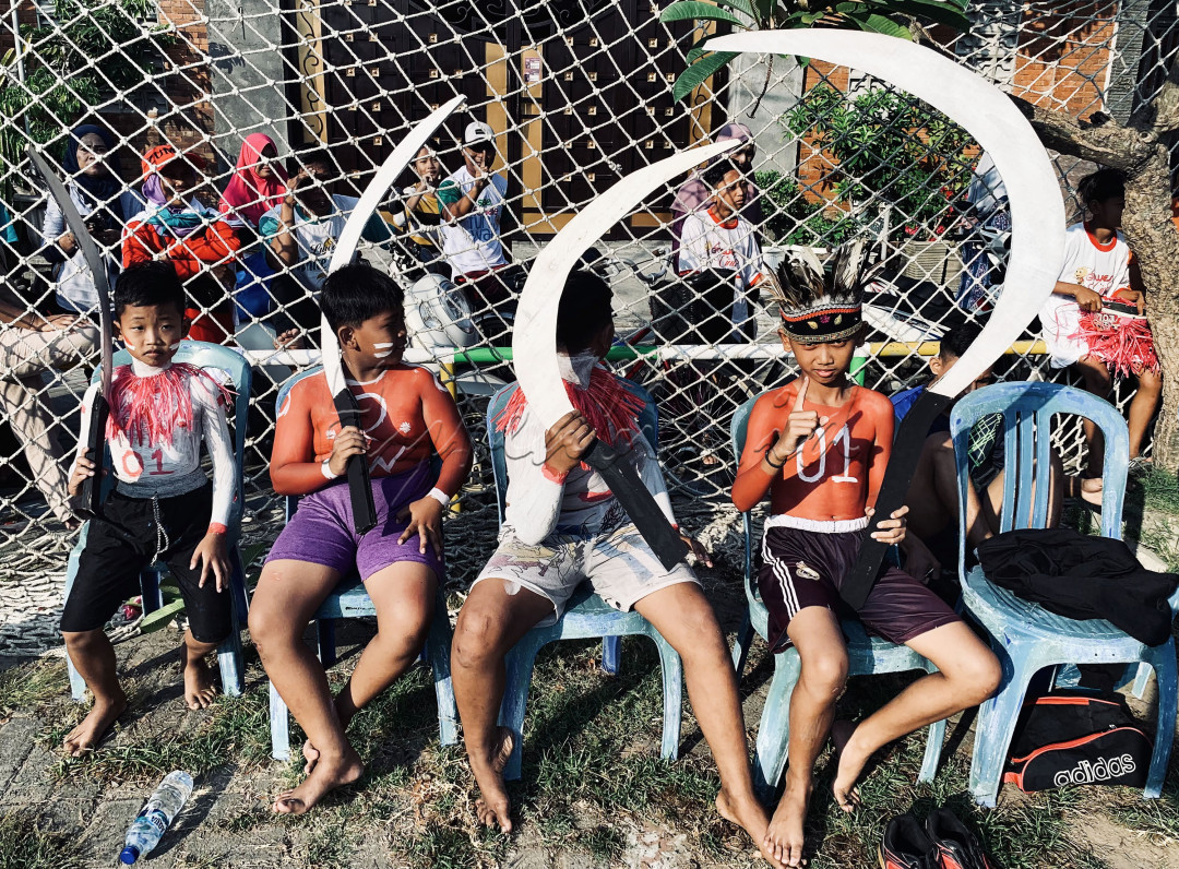 Sebuah grup anakanak dengan dandanan khas siap ikut berangkat dalam acara karnaval desa dalam rangka memperingati HUT yang ke-79 Republik Indonesia.