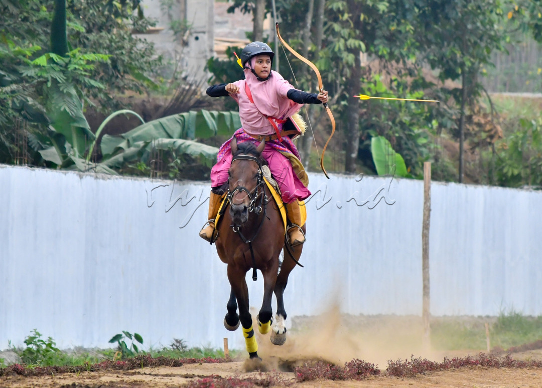 Aksi Pemanah berkuda wanita dalam Exhibition Horseback Archery pada perayaan hari santri nasional di pondok pesantren modern ZIIS Banyumas, Jawa Tengah.&nbsp;