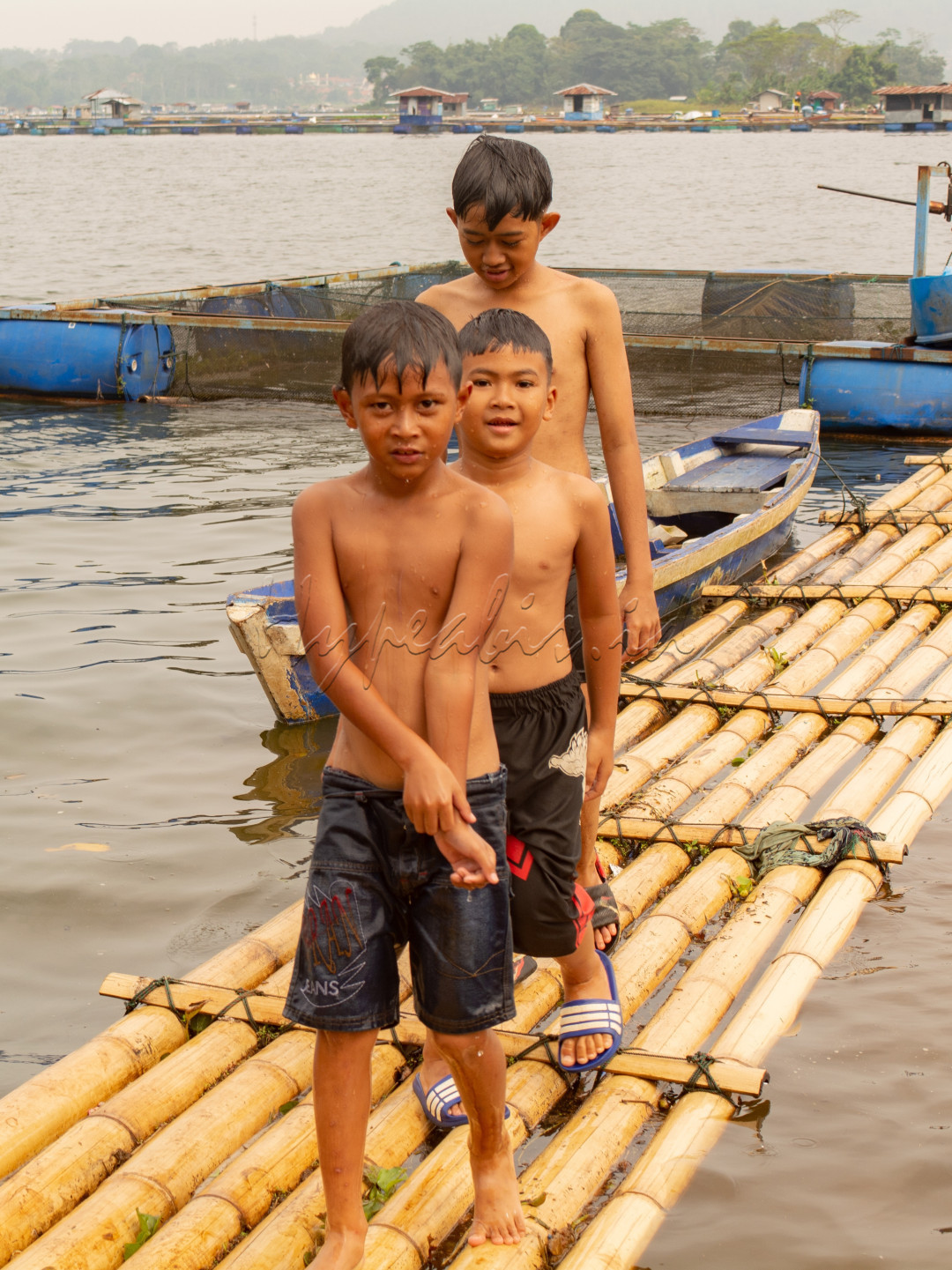 Tiga anak-anak ini saling baris usai bermain air.