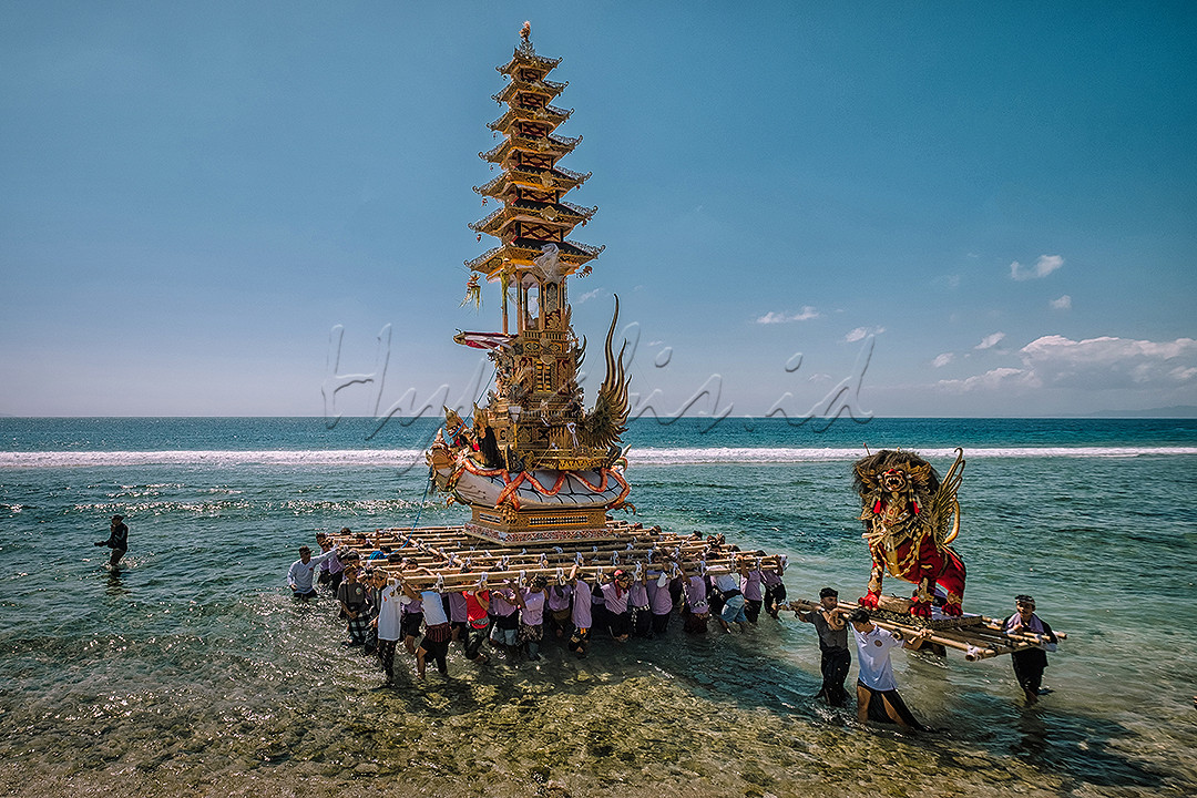 Puluhan orang bekerja sama mengarak bade dalam upacara ngaben massal di Desa Adat Karangsari, Nusa Penida, Bali.<br />
Upacara ngaben massal merupakan upacara yang diselenggarakan dengan semangat kebersamaan antar warga untuk meringankan beban biaya upacara masing-masing keluarga yang ingin melaksanakan pengabenan.