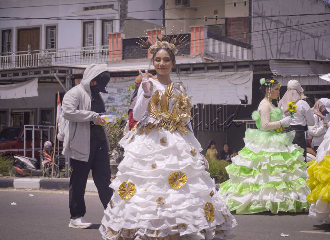 <div>Seorang peserta karnaval dengan anggun mengenakan gaun putih dan emas yang memukau, melambai penuh keceriaan dengan tanda damai. Kostum yang unik ini memadukan unsur tradisional dan modern, mencerminkan keindahan dan kreativitas dalam perayaan budaya yang meriah.</div>