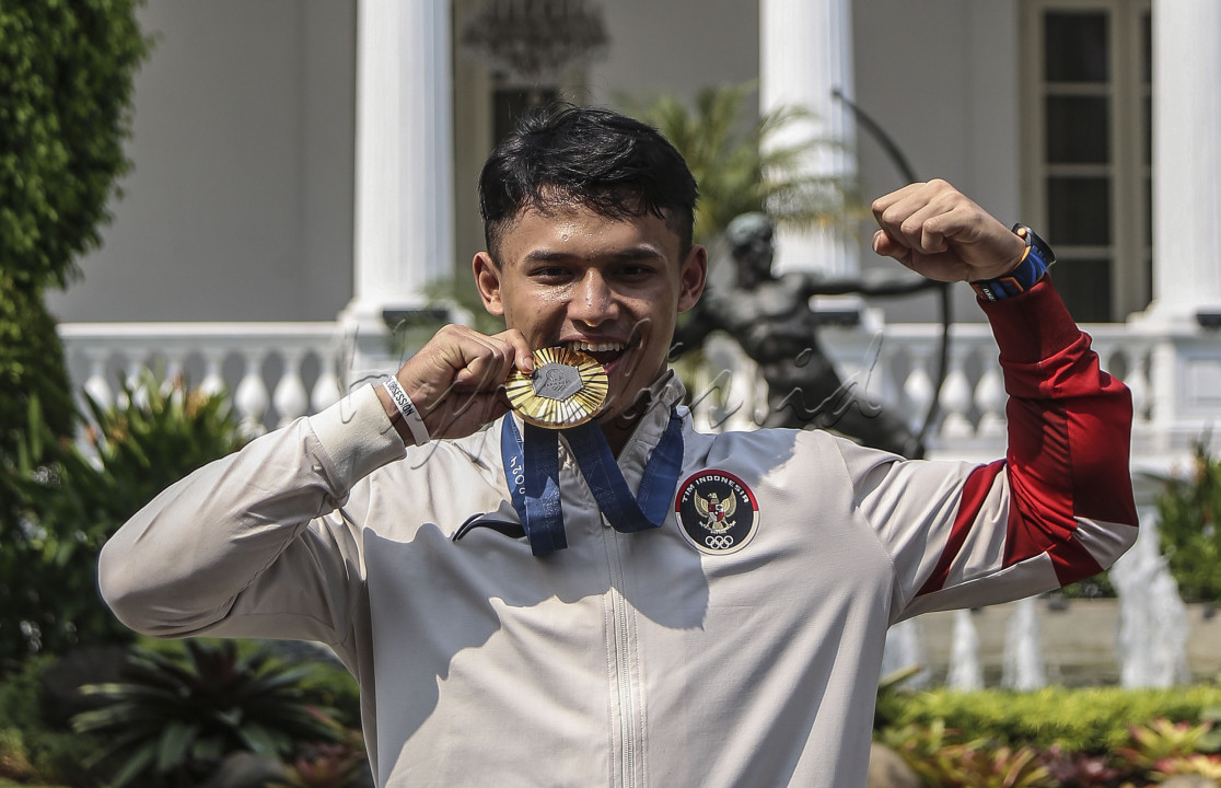 Atlet Angkat Besi nomor 73 kilogram putra peraih medali Emas Olimpiade Paris 2024 Rizki Juniansyah usai menerima bonus dari Presiden Joko Widodo di Istana Merdeka, Jakarta, Kamis (15/8/24). Presiden memberikan bonus sebagai bukti komitmen pemerintah dalam mendukung dan memajukan olahraga nasional. FOTO : DWI PAMBUDO<br />
&nbsp;