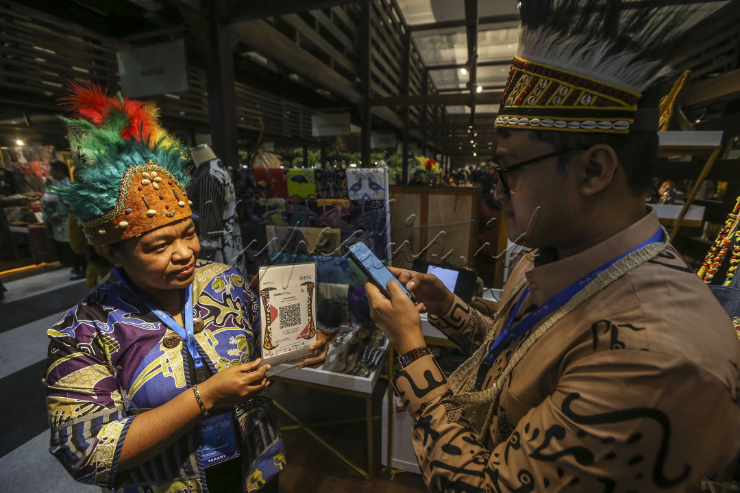 Pengunjung melakukan pembayaran QRIS saat membeli produk UMKM Papua Barat di Jakarta, Kamis (1/8/2024). Transformasi Ekonomi Keuangan Digital (EKD) nasional dalam rangka menciptakan ekonomi &amp; keuangan yang inklusif, mendukung inovasi, dan meningkatkan daya saing UMKM Indonesia. FOTO : DWI PAMBUDO<br />
&nbsp;