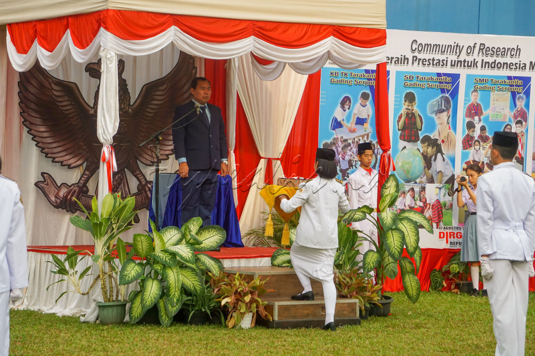Penyerahan Sang Merah Putih kepada Pasukan Pengibar Bendera oleh Pembina Upacara.