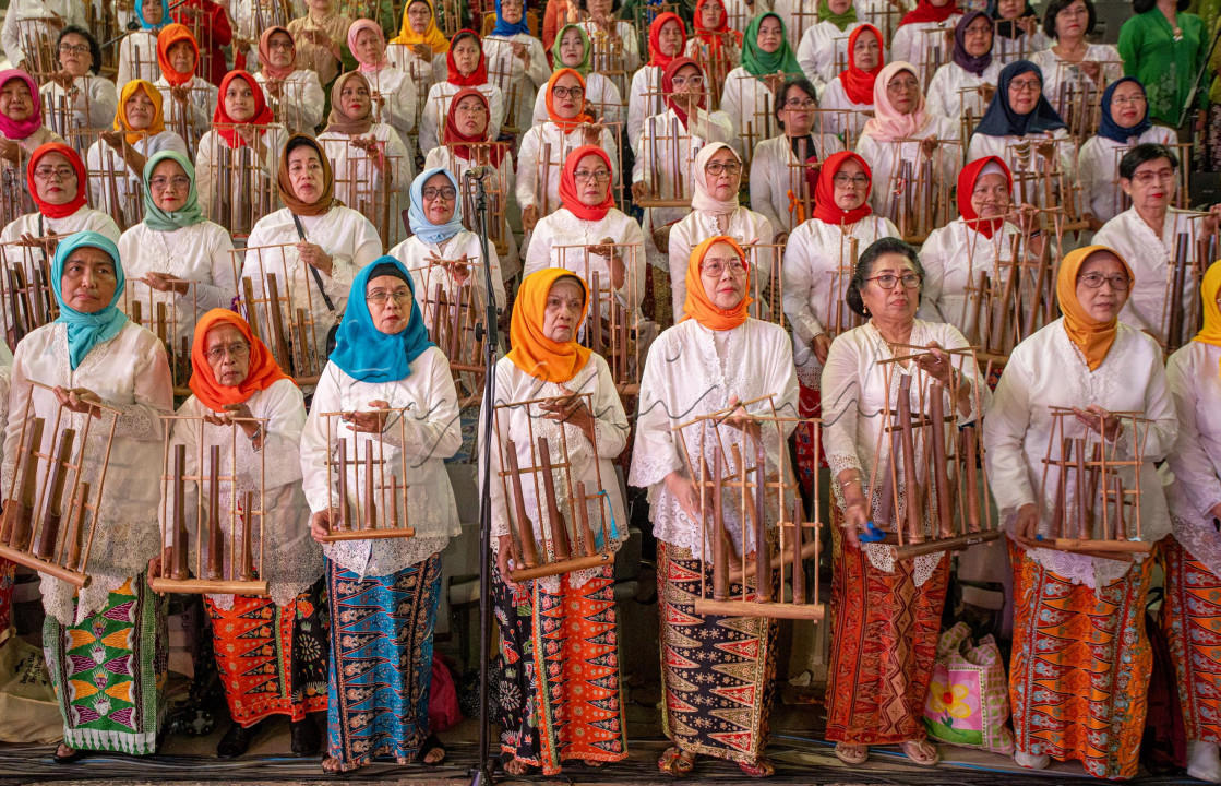 Wanita Indonesia merayakan hari Kebaya dengan memainkan lagu Indonesia dengan angklung