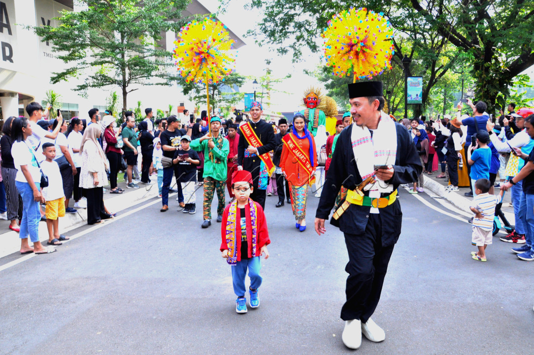 Seorang anak bersama orang tua nya menggunakan baju adat Betawi mengikuti&nbsp; arak-arakan dalam rangka memeriahkan ulang tahun Jakarta ke-497 di Taman Mini Indonesia Indah (TMII) Jakarta, Sabtu 22 Juni 2024<br />
&nbsp;