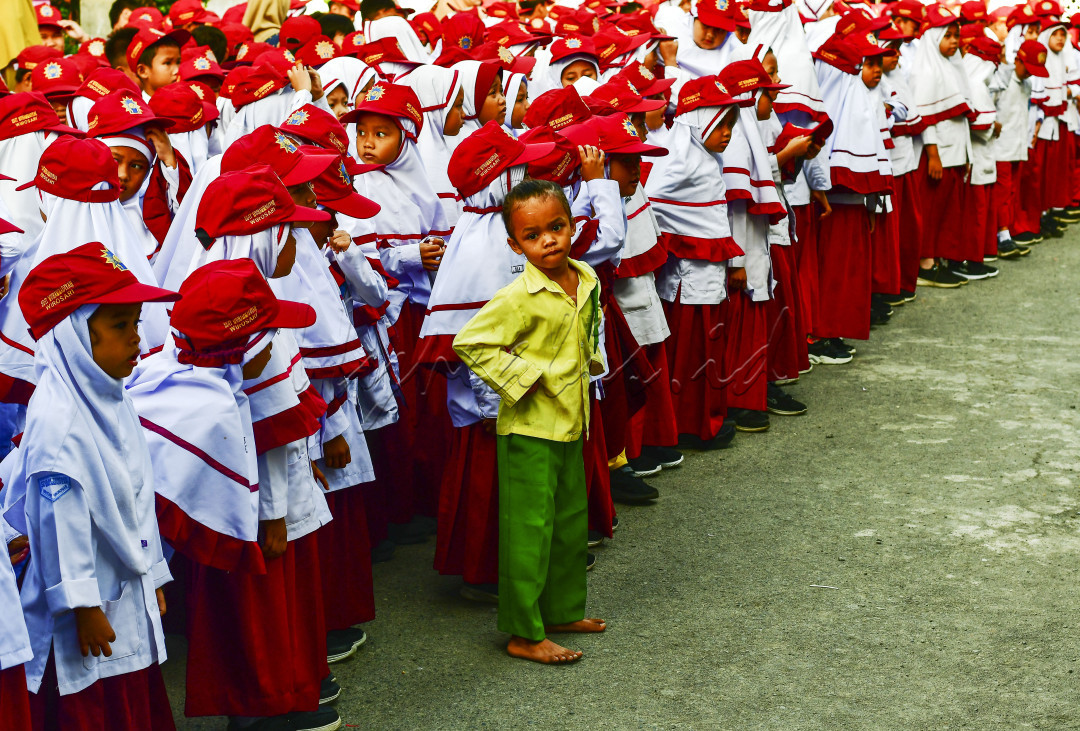 Seorang murid TK dengan seragam berwarna kuning hijau ikut nimbrung dalam barisan murid SD saat mengikuti upacara bendera di Kabupaten Grobogan, Jawa Tengah, Senin, 19 Agustus 2024.