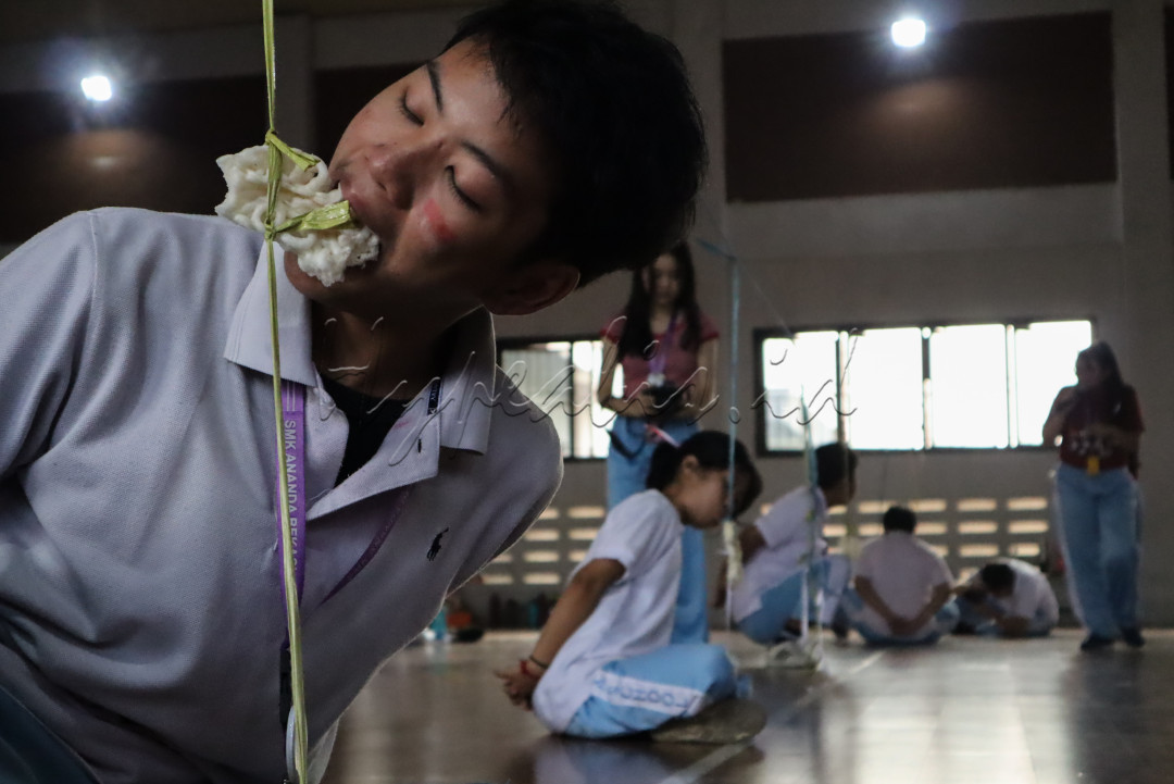Momen penuh semangat saat seorang peserta berusaha sekuat tenaga untuk memenangkan lomba makan kerupuk. Ekspresi gigih ini menjadi simbol perjuangan dalam merayakan kemerdekaan, menghadirkan keceriaan khas 17an.