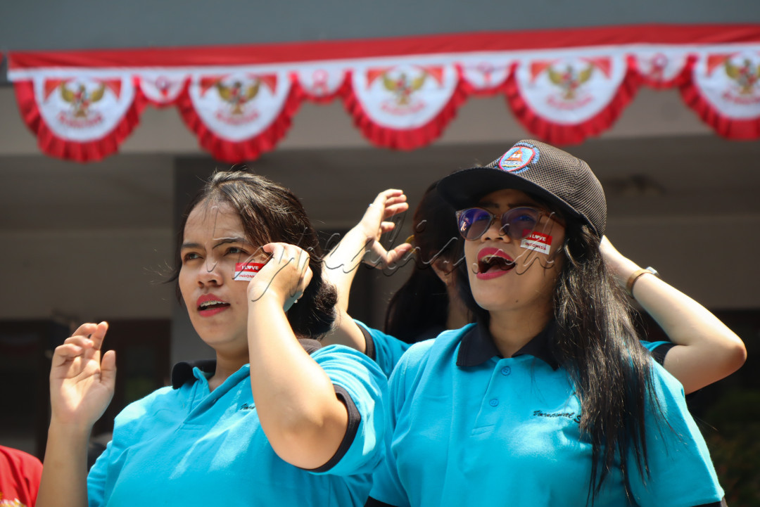Dua wanita penuh semangat bersorak mendukung tim mereka, menularkan energi positif dan keyakinan untuk meraih kemenangan. Momen ini mencerminkan solidaritas dan semangat kebangsaan yang menghidupkan suasana perayaan 17an.