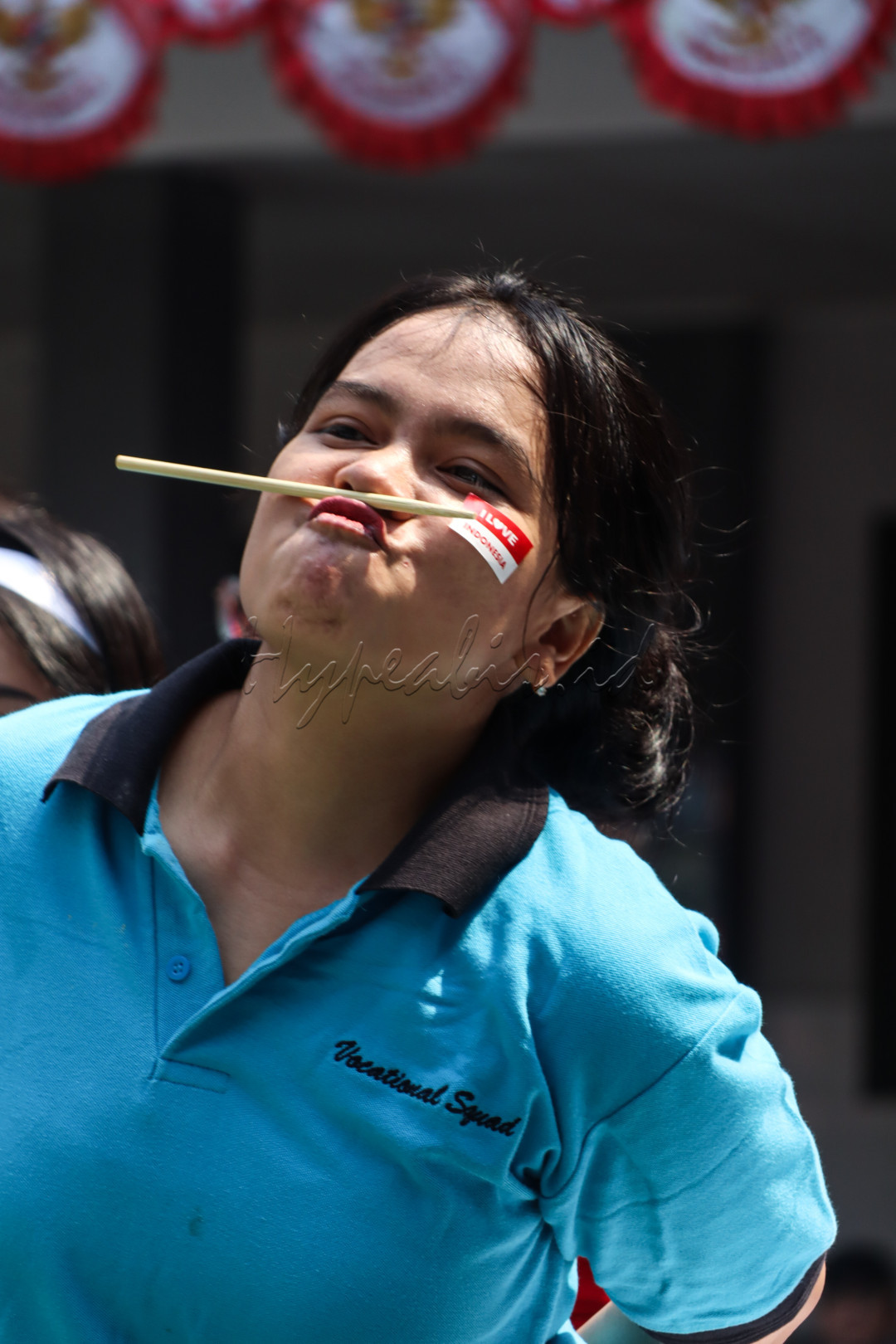 Potret usaha maksimal saat mengikuti lomba membawa sumpit di antara mulut dan hidung. Dengan fokus dan tekad yang tinggi, setiap langkah lari adalah simbol perjuangan dan ketangguhan dalam merayakan semangat 17an.
