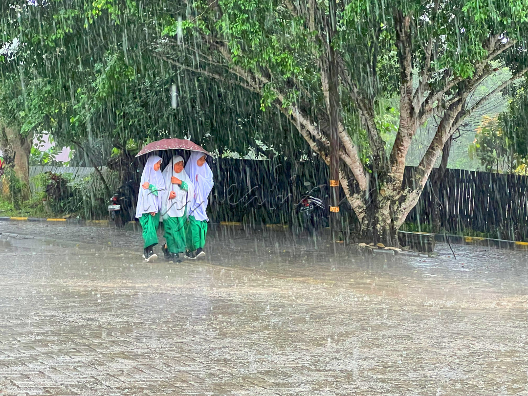 Sejumlah peserta didik jenjang sekolah dasar menggunakan satu payung bersama menembus hujan deras pada jam istirahat sekolah di Gunung Tembak, Kelurahan Teritip, Kecamatan Balikpapan Timur, Kota Balikpapan, Kalimantan Timur, 7 Agustus 2024.*